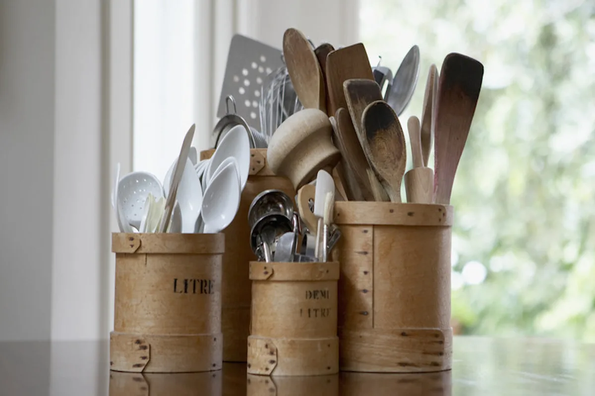 Kitchen utensils in containers on table